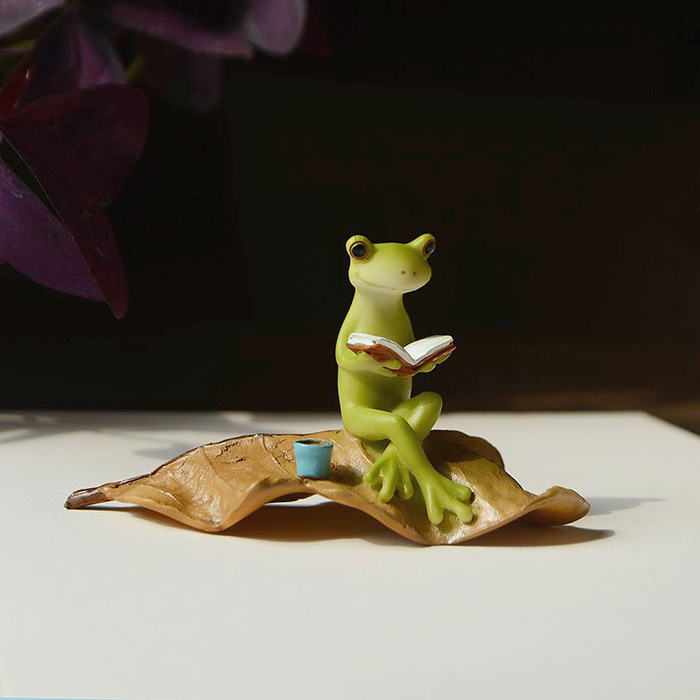 FROG READING ON LEAF